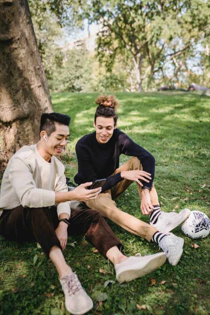 Zwei Freunde, die im Park zusammen sitzen