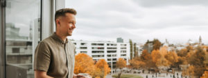 Junger Mann mit Kaffee der auf den Stadtteil schaut